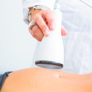 Il Medico Estetico dello Studio Vircos di Roma San Giovanni esegue un trattamento di Cavitazione sulla pancia di una Paziente.